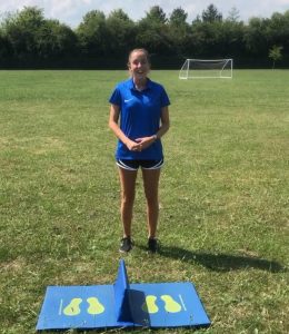 A female PE teacher stands in a school field